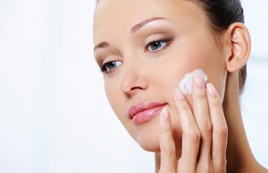 woman caring of her face with moisturizer cream